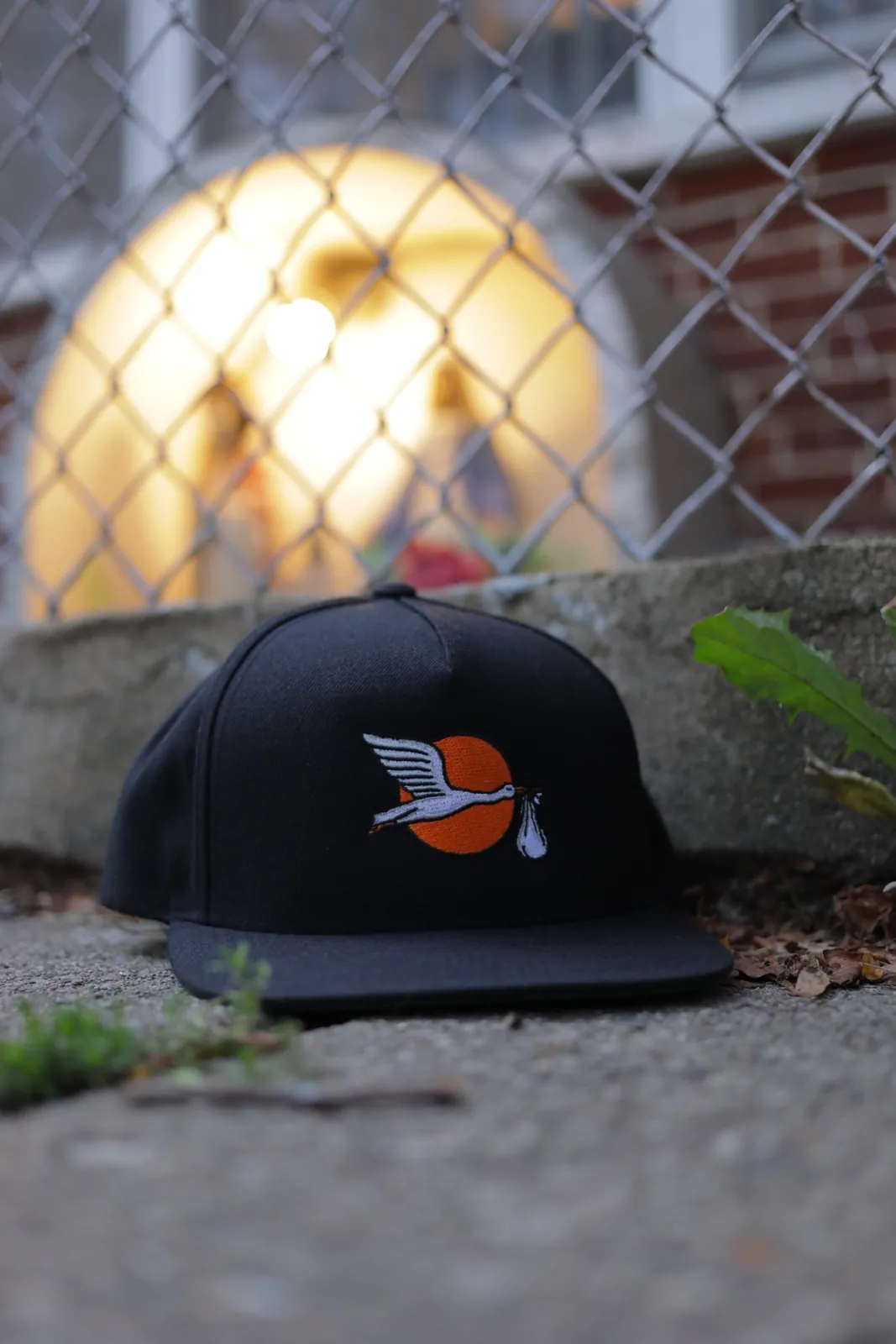 Navy embroidered cap photographed beside a chain-link fence