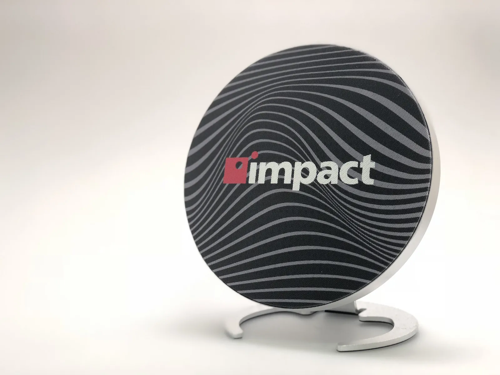 Circular impact speaker with black and gray wave graphics